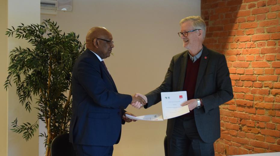 Yero Baldeh, Director of the Transition States Coordination Office, African Development Bank and Dan Smith, SIPRI Director, shake hands on the new partnership.