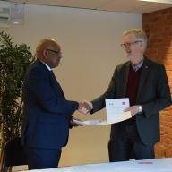 A representative from the African Development Bank and Dan Smith, SIPRI Director, shake hands on the new partnership.