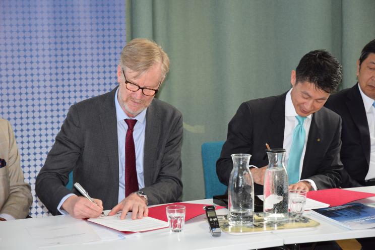 Dan Smith and Hidehiko Yuzaki signing Memorandum of Understanding