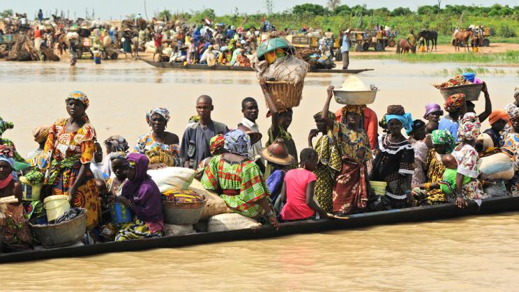 People taking a boat across a river in Djenne, Mali