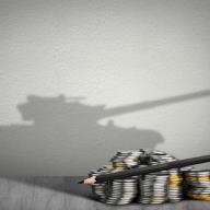 Coins with shadow of military tank