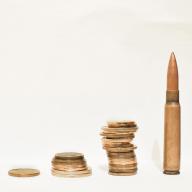 Piles of coins next to a bullet